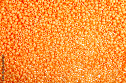 Flame-orange glass beads background - closeup beads texture © leyag