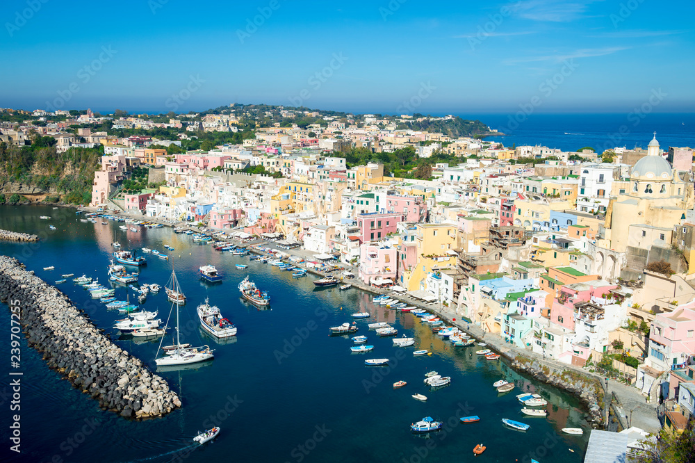 Bright scenic overlook view of the colorful traditional hillside architecture of Corricella harbour on the island of Procida, Italy