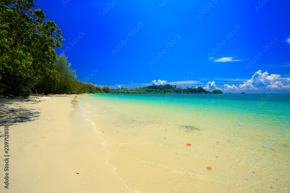 A fishing boat floating on beach with clean and clear sea and cloudy blue sky. Copy space.	