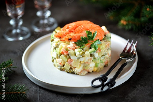 Traditional Russian salad "Olivier" with shrimps and avocado. Christmas background.