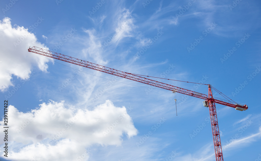 Construction concept. Red tower crane under cloudy sky background. Under view, space. Construction concept. Red tower crane under cloudy sky background. Under view, space.