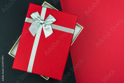 Open Red gift box with bow on black and grey background