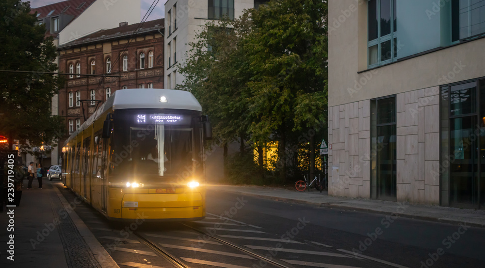 Public transportation concept. Yellow electric tram at Berlin, Germany. City and people background.