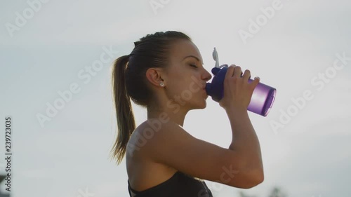Athletic girl drinking water