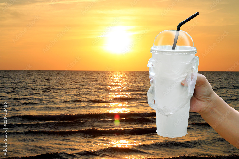 paper cup white and straws in hand over sea beach sunset evening, fast food  cup plastic