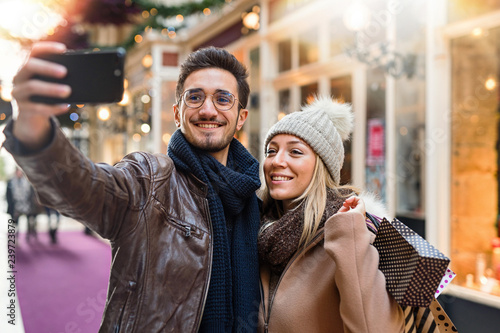 A young couple do a selfie in the decorated street for Christmas