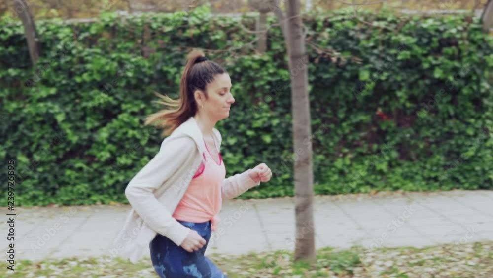 Slowmotion video of fit woman running in the park . morning sport training Slowmotion video of fit woman running in the park . morning sport training