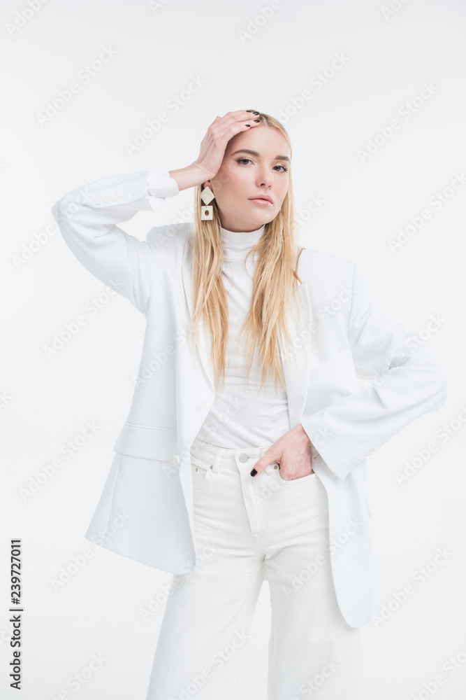 attractive caucasian blonde woman in fashionable white clothes touching head and posing isolated on white attractive caucasian blonde woman in fashionable white clothes touching head and posing isolated on white
