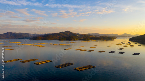 瀬戸内海の虫明沖合、長島より離陸して朝日の上る海面と牡蠣いかだのある穏やかな風景が美しい photo