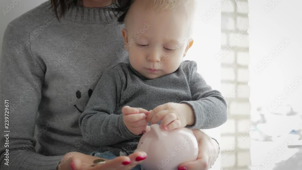 Mother and little son putting coins into piggy bank for the future savings. Mother and little son putting coins into piggy bank for the future savings.