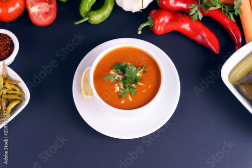 Tomato soup bowls on dark background. Top view. Copy space.