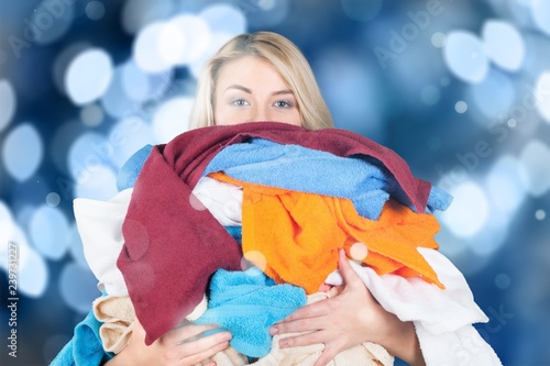 Young Tired Woman Carrying heap of different clothes