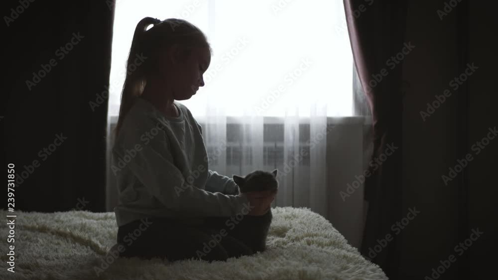 Depressed little girl hugging teddy bear.