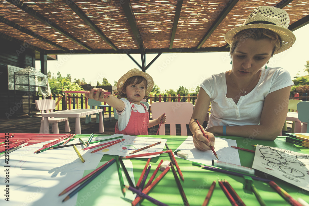 mom and little daughter drawing a colorful pictures
