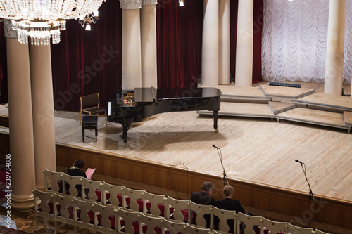 Piano on scene and viewers in the concert hall