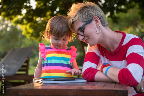 mom and her little daughter using tablet computer