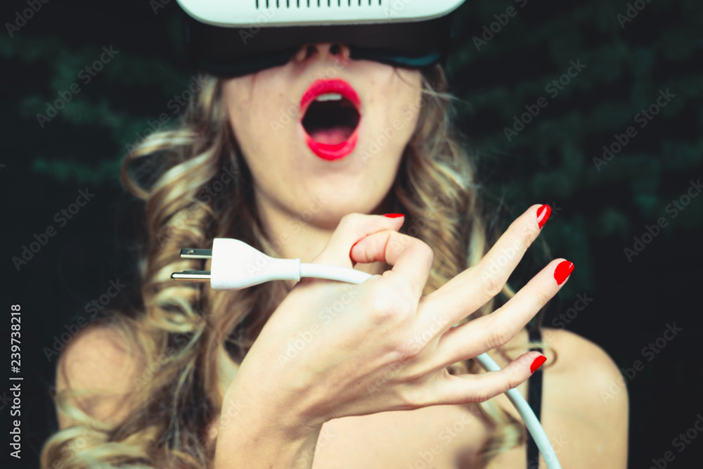 Beautiful attractive girl holds a cable in her hand and widely opened mouth  with tongue sticking out. Illustration of virtual oral sex. Concept of  increasing potency through the Internet and blowjob Stock