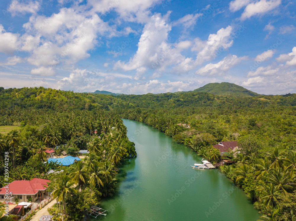 Aerial drone view to Loboc river. Mountain river flows through green forest. Bohol island, Philippines