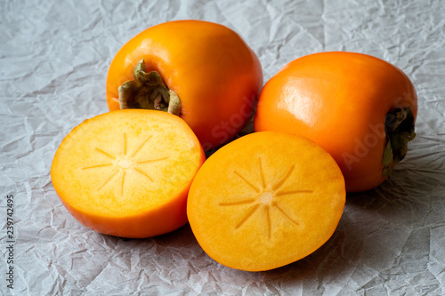 Fotografi Whole and half of fresh ripe persimmons