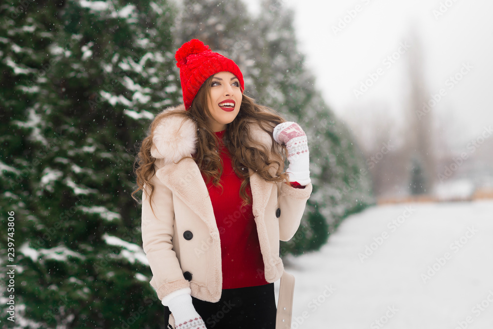 Winter day. Winter walk with a happy girl in a red hat. Winter holidays and weekends. Positive mood.