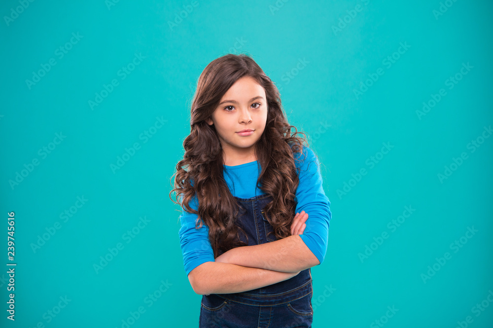 Upbringing confidence. Kid girl long hair posing confidently. Girl curly hairstyle feels confident. Child hold hands confidently crossed chest. Child psychology and development. Confident posture Upbringing confidence. Kid girl long hair posing confidently. Girl curly hairstyle feels confident. Child hold hands confidently crossed chest. Child psychology and development. Confident posture