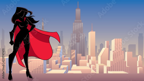 Silhouette superheroine standing tall against city background.