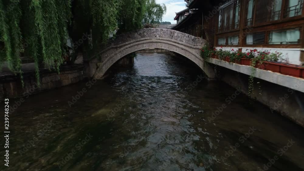 Aerial drone shot flying away from narrow canals and courtyard homes and hotels, reveals stunning historic architecture of Lijiang old town, travel tourism culture China Aerial drone shot flying away from narrow canals and courtyard homes and hotels, reveals stunning historic architecture of Lijiang old town, travel tourism culture China
