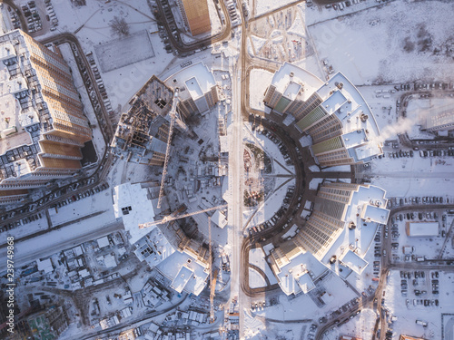Top view of curved house. New high-rise buildings in snow. Drone top down view
