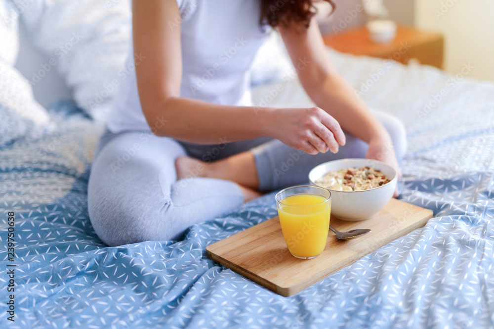 Healthy morning breakfast in a bed. Blurred figure of woman holding tablet.