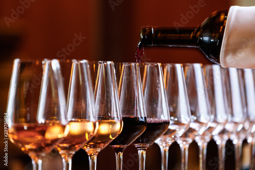 Wine glasses in a row. Pouring wine. Buffet table celebration of wine tasting. Nightlife, celebration and entertainment concept