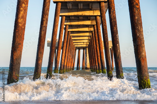 pier on the beach with crashing waves (costa azul, rio das ostras, rio de janeiro, brazil)