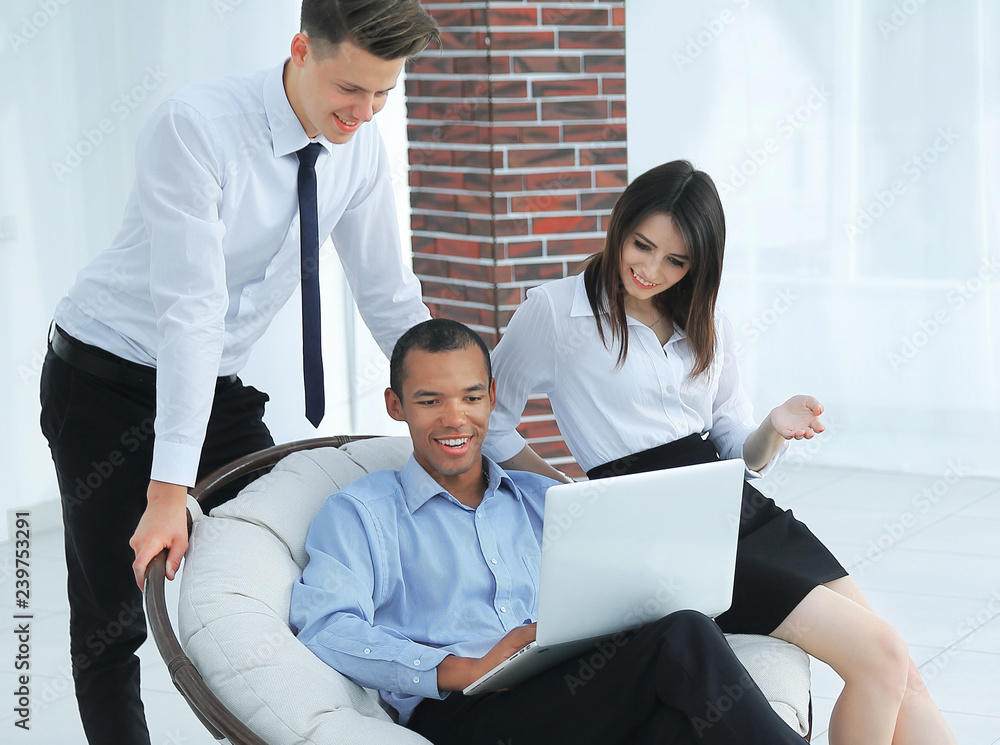 successful businessman with his assistants in a discussion of the information from the laptop. successful businessman with his assistants in a discussion of the information from the laptop.