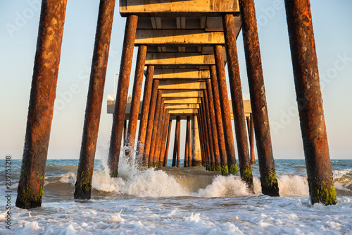 pier on the beach with crashing waves (costa azul, rio das ostras, rio de janeiro, brazil)
