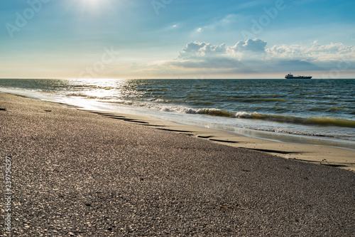 Fotografija Nature, water, environment and paysage concept: view of the North Sea, ship in the background and clouds