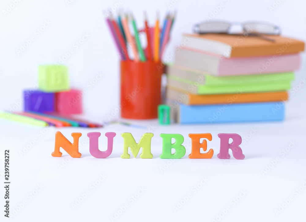 word number on blurred background of school supplies .photo with word number on blurred background of school supplies .photo with