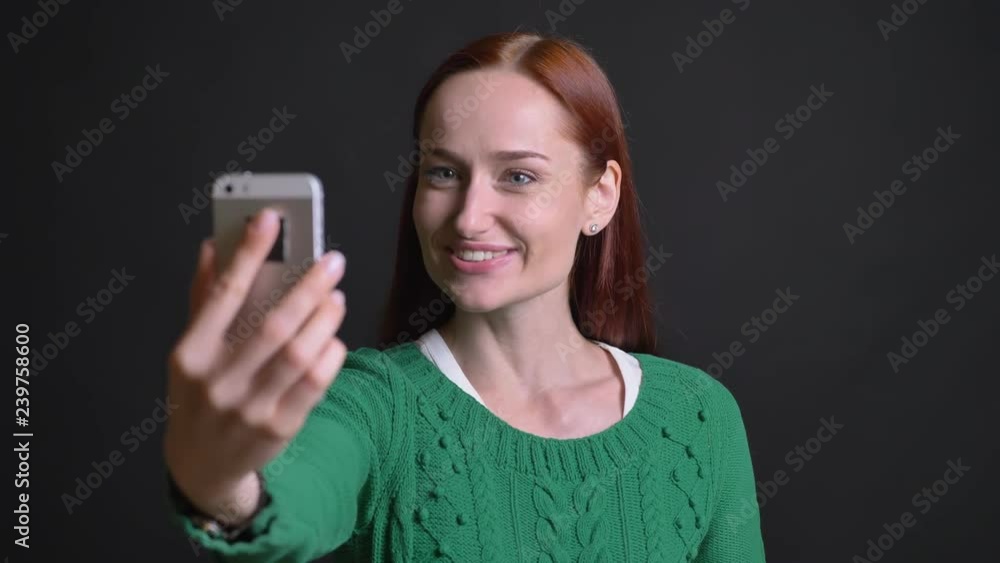 Closeup portrait of attractive caucasian female having a video call on the phone in a positive mood Closeup portrait of attractive caucasian female having a video call on the phone in a positive mood