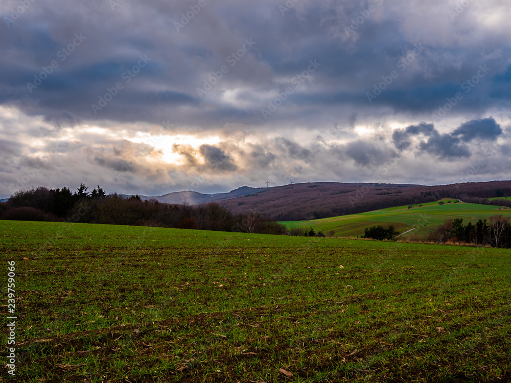 landscape of a valley with sun behind clouds in germany
