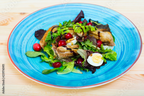 Salad of quail with greens, cranberries and honey-ginger sauce
