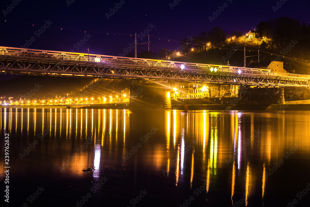 Train bridge of Meißen in Germany at night with light reflections in the water.
