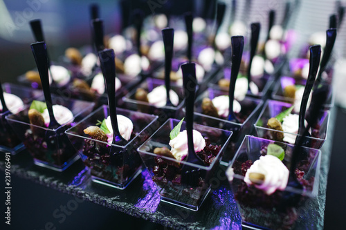 Beautifully decorated catering banquet table with profiteroles, salads and cold snacks. Variety of tasty delicious snacks on the table. Wedding table serving. Meat and vegetables