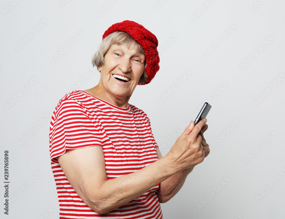 old grandmother is talking to her grandchildren by phone, smiling and greeting them.Close up. old grandmother is talking to her grandchildren by phone, smiling and greeting them.Close up.