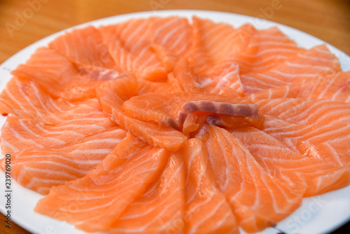 Slided Raw Salmon in white dish on wood blackground