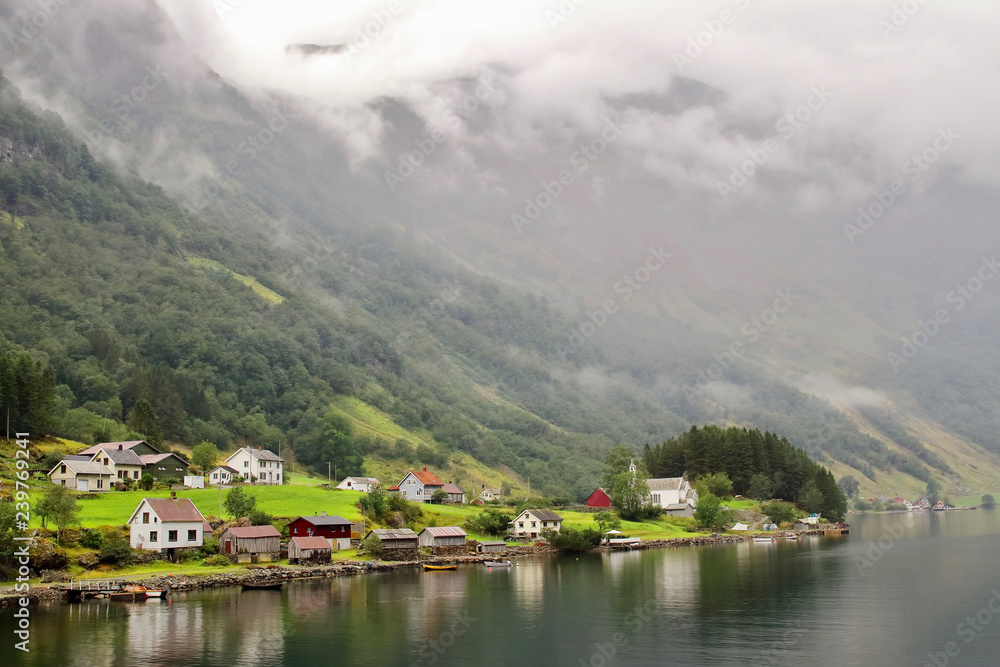 Fototapeta premium Main view of Bakka, a tiny village in the municipality of Aurland in Sogn og Fjordane county, Norway. It is located on the western shore of the Nærøyfjord 5 kilometres north of Gudvangen village.