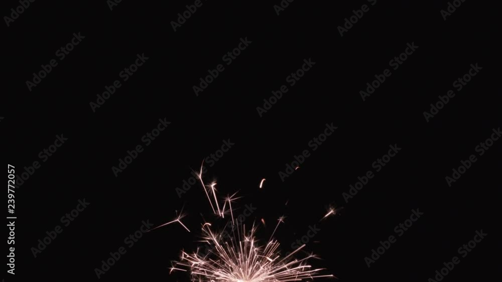 burning Christmas sparkler against black background burning Christmas sparkler against black background