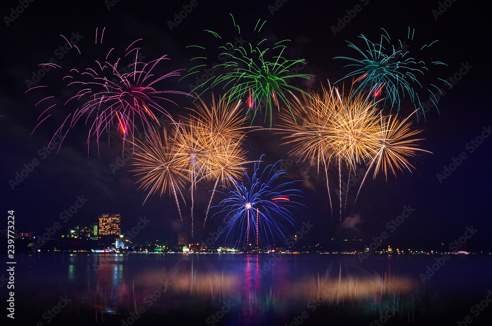 Fototapeta premium Colorful fireworks celebration and the city night light with twilight sky background.
