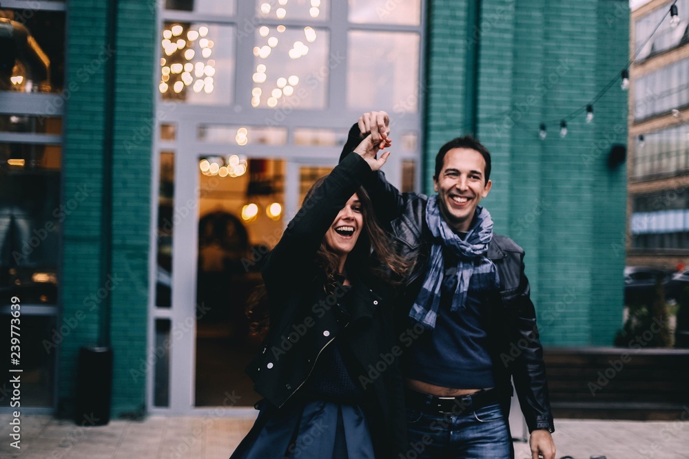 beautiful couple in love walks and dances in the Christmas evening city. Date in the cold. beautiful couple in love walks and dances in the Christmas evening city. Date in the cold.