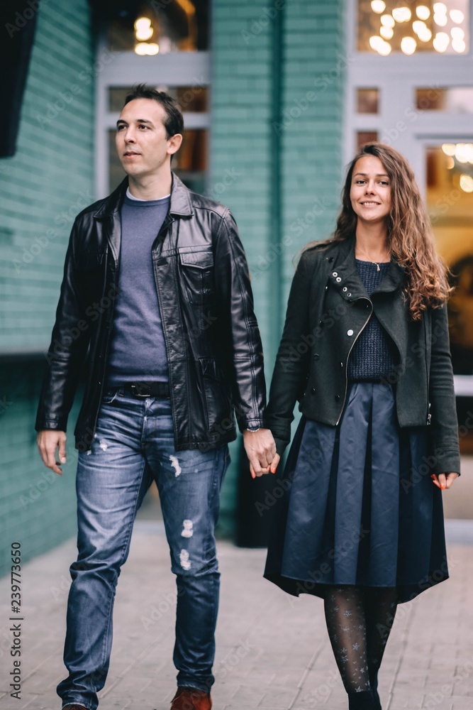 couple in love walks around the city in fashionable clothes.