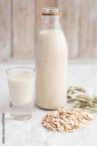 oat milk in a glass bottle with oat seeds