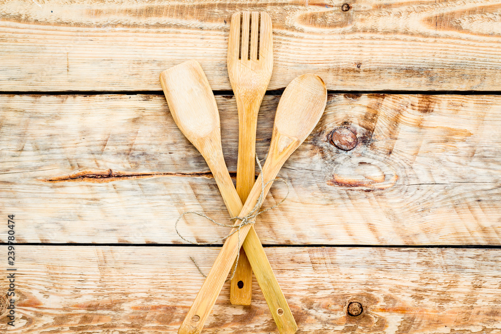 Fork, spoon in woodenware set on wooden background top view
