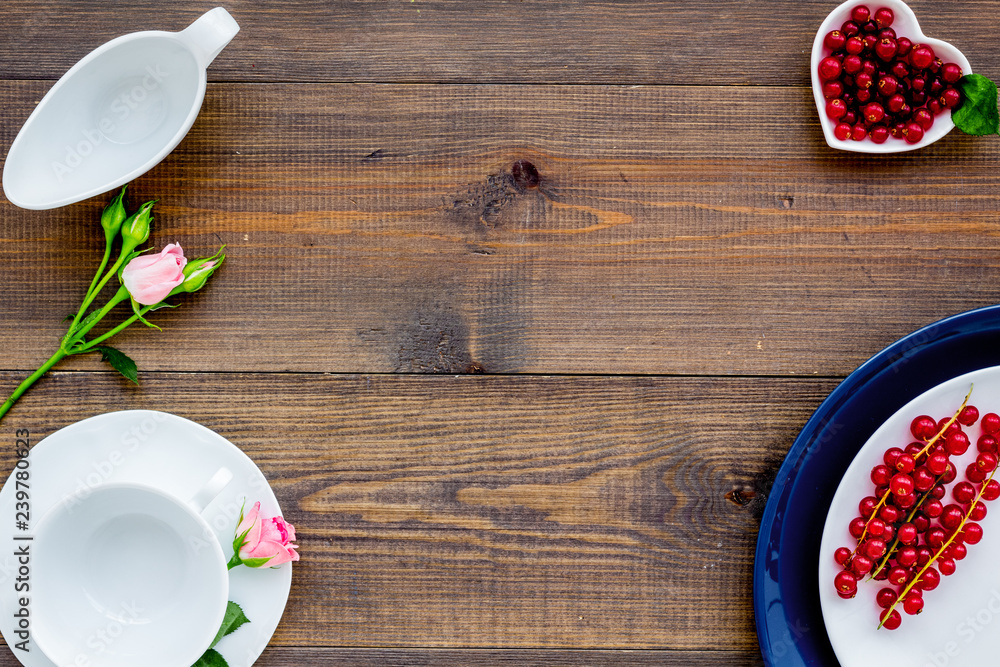 Elegant table setting with white plates, wineberry and floral decor on wooden background top view mockup